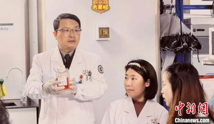 图为杨清武教授(左)指导研究生做试验。　曾理 摄